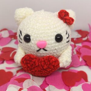 chat au crochet avec un coeur rouge